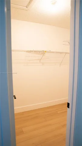 an empty room with wooden floor & windows