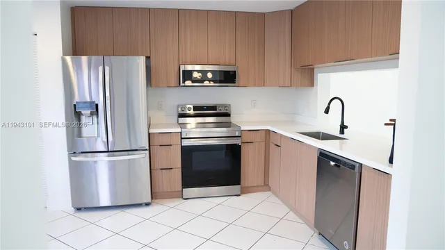 a kitchen with a refrigerator sink and white cabinets