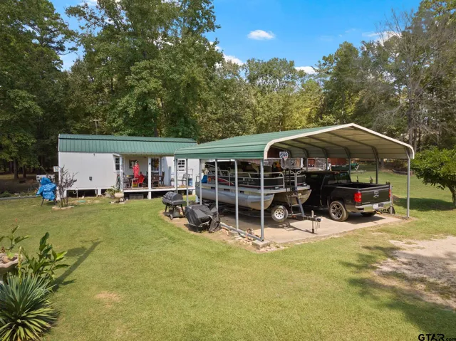 a view of house with a big yard and potted plants