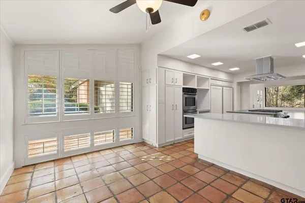 a dining room with furniture potted plants and wooden floor