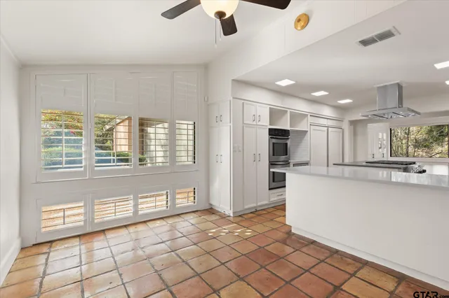 a dining room with furniture potted plants and wooden floor