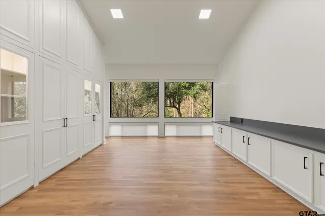 a view of a big room with wooden floor and windows