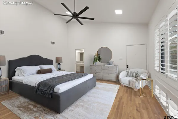 an empty room with wooden floor fan and windows
