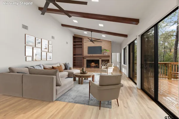 a view of empty room with wooden floor and fireplace