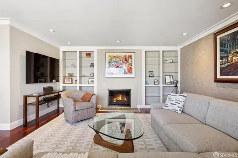 a living room with furniture a flat screen tv and a fireplace