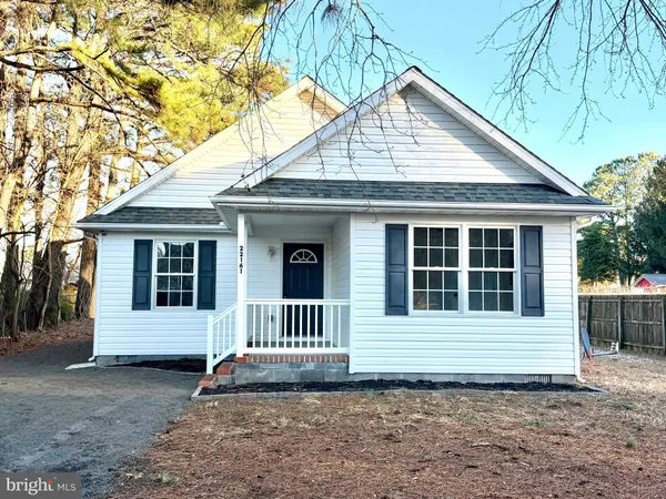 a view of a house with a small yard and wooden fence