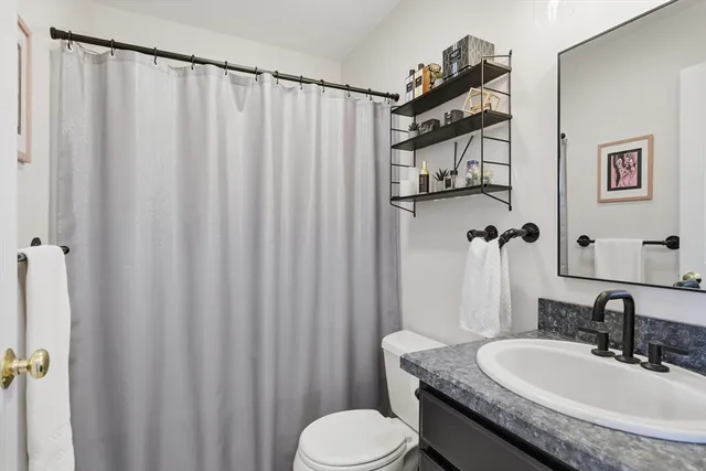 a bathroom with a granite countertop sink toilet and shower
