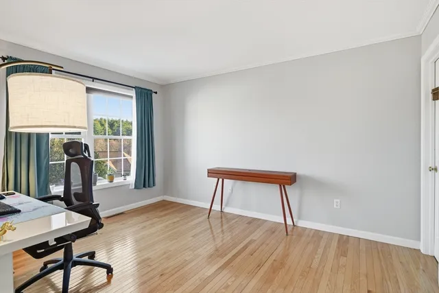 a view of a workspace with furniture and a window
