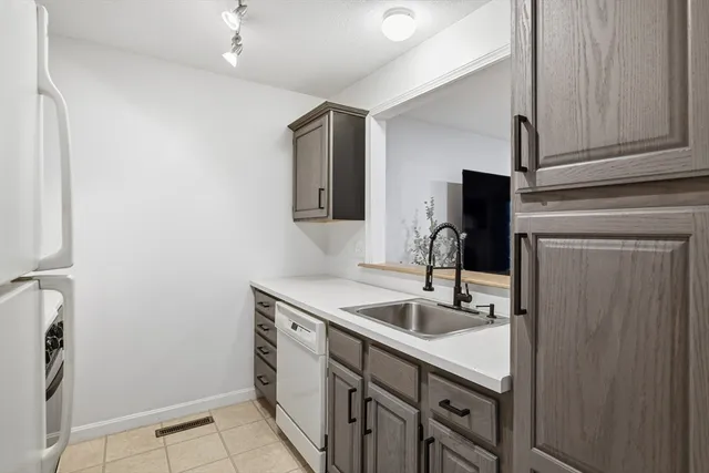 a kitchen with stainless steel appliances granite countertop a sink and a refrigerator