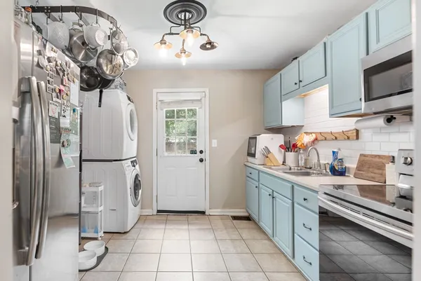 a kitchen with stainless steel appliances a refrigerator sink and microwave