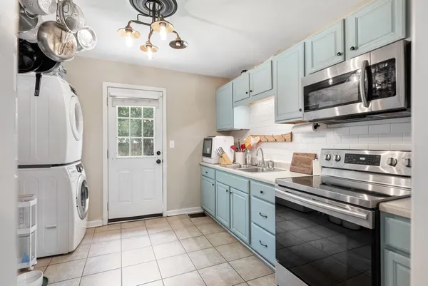 a kitchen with stainless steel appliances granite countertop a refrigerator a stove a sink and a microwave