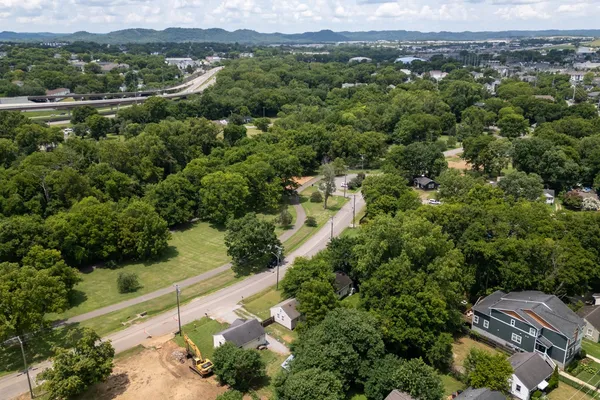 an aerial view of residential houses with outdoor space and trees