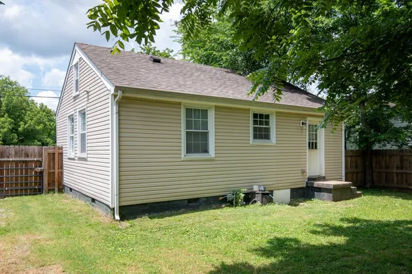 a view of backyard with house and trees in the background