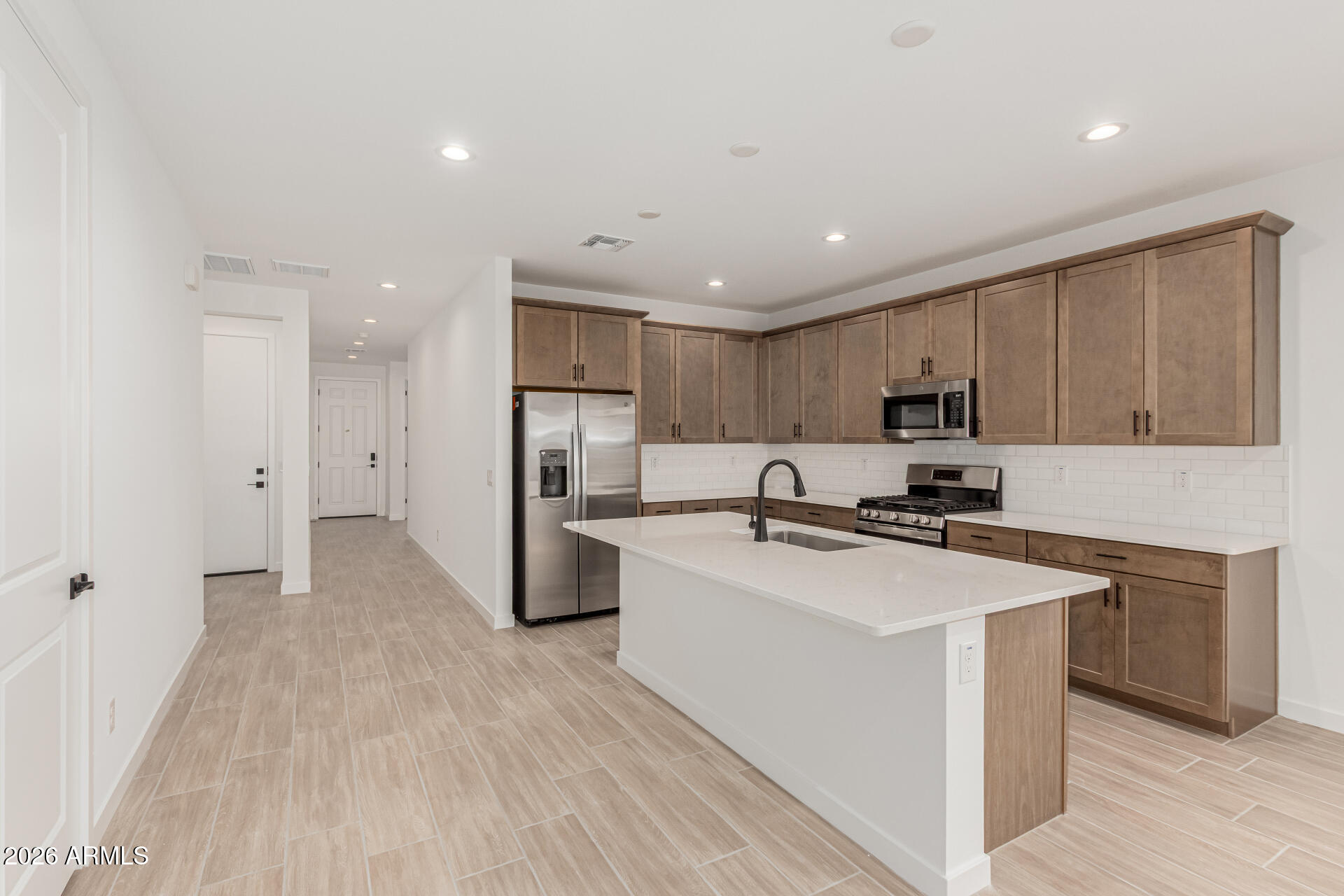 8029 West Granada Road Phoenix, AZ 85035 - Photo 3 of 35 a kitchen with stainless steel appliances a refrigerator sink and white cabinets