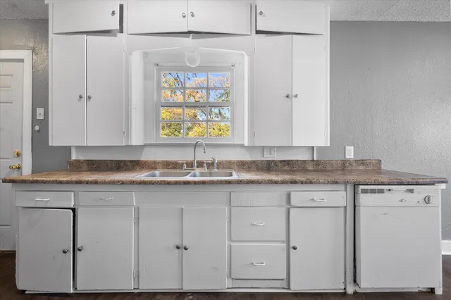 a kitchen with granite countertop a sink white cabinets and a granite counter tops