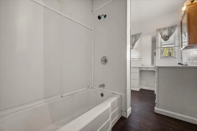 a bathroom with a tub shower and sink
