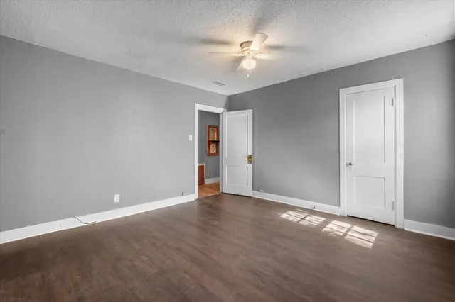 a view of an empty room with chandelier fan