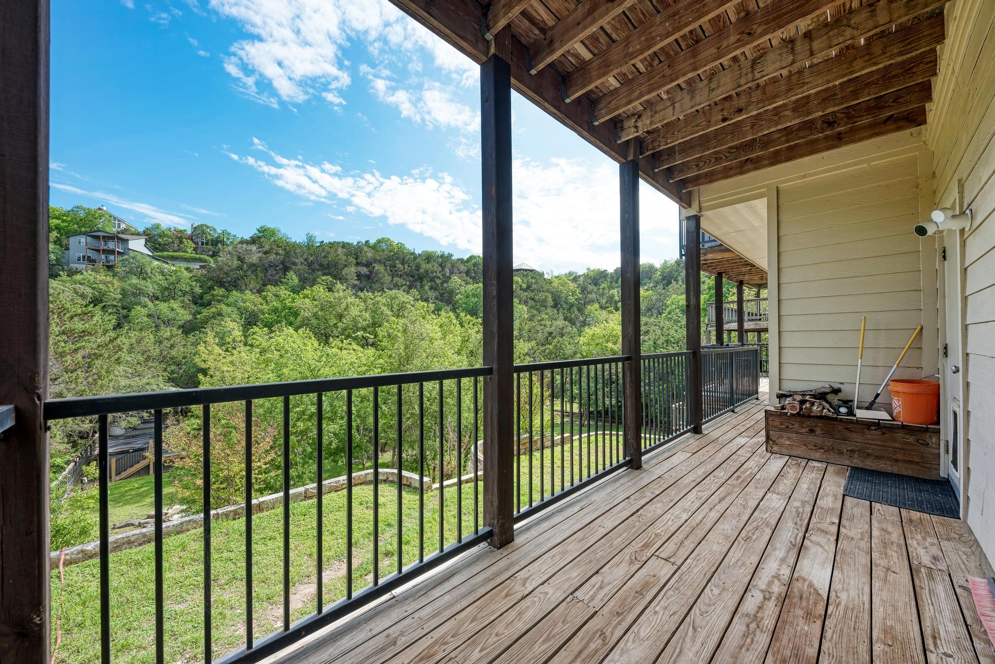 2605 Indian Creek Road Austin, TX 78734 - Photo 28 of 33 Expansive wood-decked balcony featuring black metal railings and overhead wood beam construction
