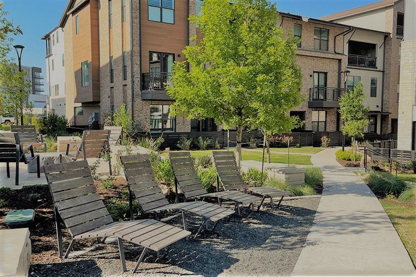 a view of a patio with couches table and chairs and potted plants