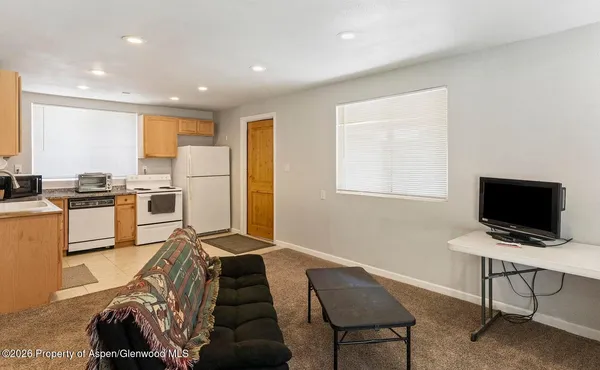 a view of a workspace with furniture and a window