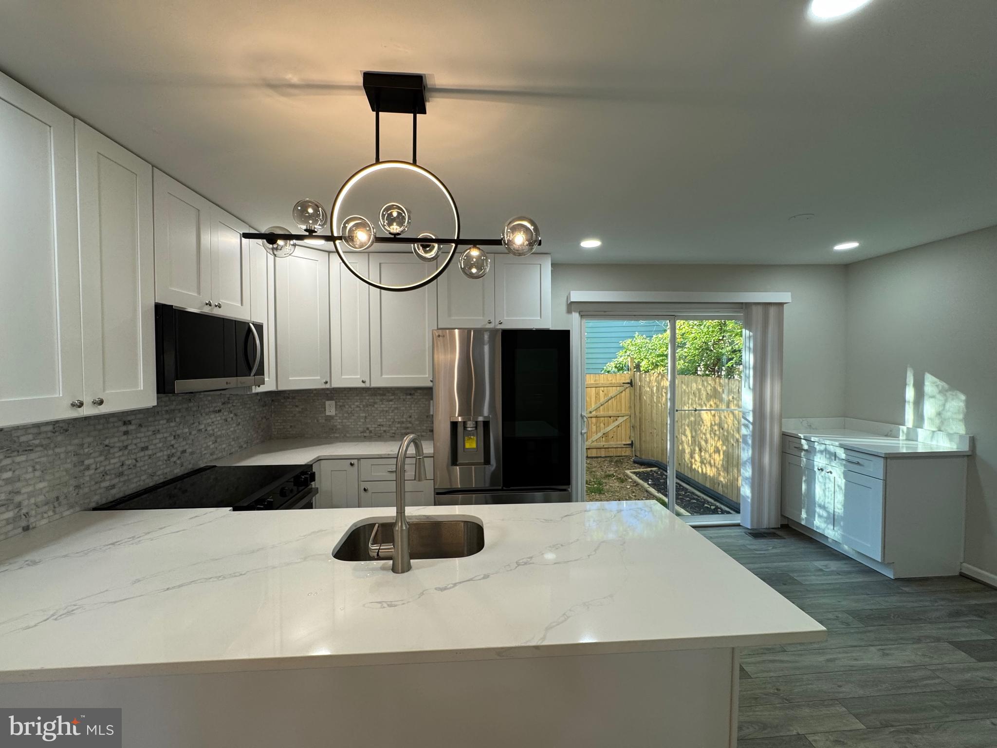 1202 Barnaby Terrace Southeast Washington, DC 20032 - Photo 3 of 21 a kitchen with stainless steel appliances a sink a microwave a refrigerator and cabinets