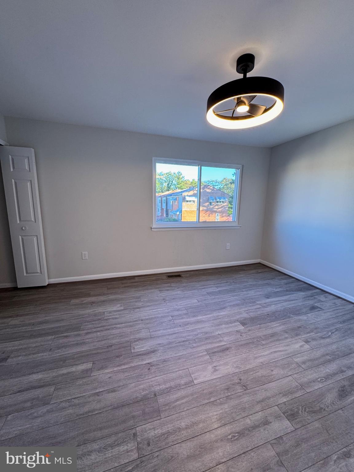 1202 Barnaby Terrace Southeast Washington, DC 20032 - Photo 8 of 21 an empty room with wooden floor and chandelier