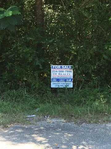 a sign that is sitting in front of a tree