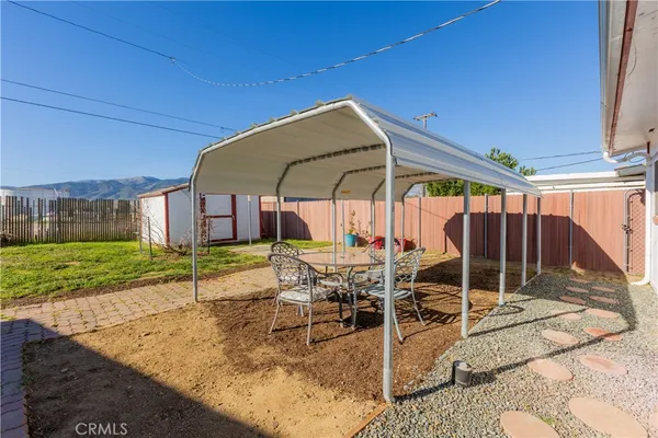 a view of a patio with a table and chairs under an umbrella