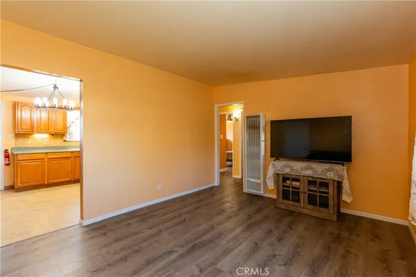 a view of a livingroom with wooden floor and a flat screen tv