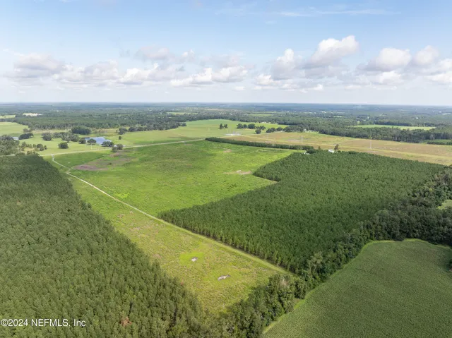a view of a field with houses in back