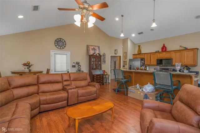 a living room with furniture kitchen view and a chandelier