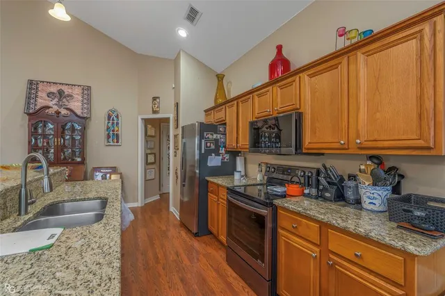 a kitchen with stainless steel appliances granite countertop a sink dishwasher stove and cabinets