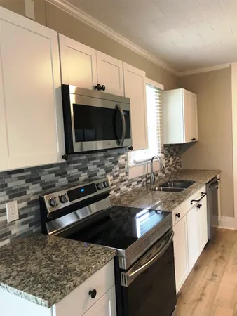 a kitchen with a stove a microwave and sink