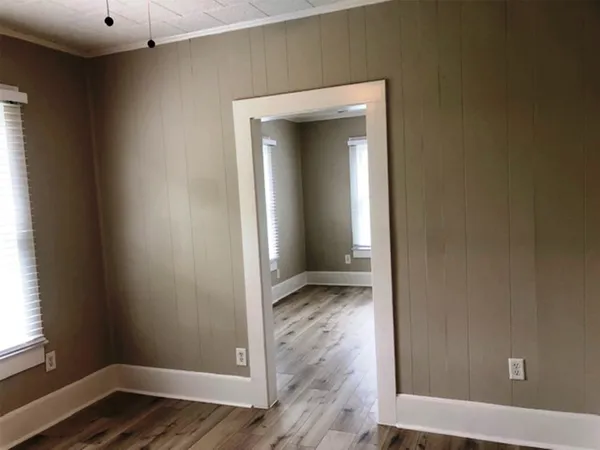 an empty room with wooden floor and closet