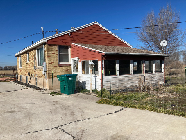 200 South 2800th Street West Ogden, UT 84404 - Photo 18 of 42 View of side of property featuring a sunroom and a shingled roof