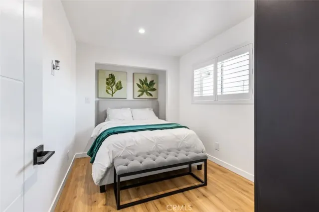 a bedroom with a bed and wooden floor