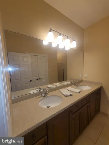 a spacious bathroom with a toilet a sink a mirror and a shower