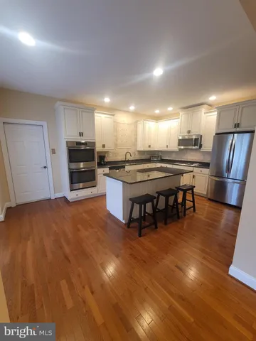 a kitchen with stainless steel appliances granite countertop a stove refrigerator and cabinets