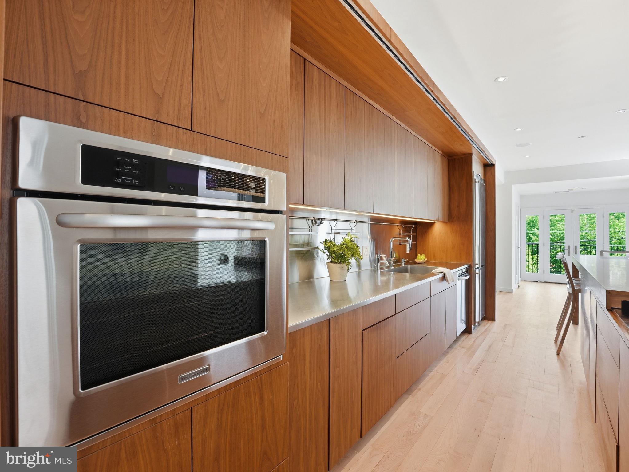 1845 Calvert Street Northwest Washington, DC 20009 - Photo 15 of 48 a kitchen with stainless steel appliances kitchen island granite countertop a stove a microwave and a sink