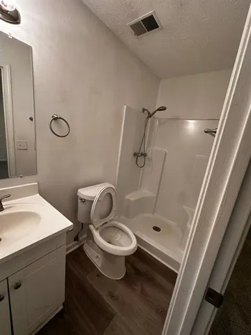 a bathroom with a granite countertop sink toilet and shower
