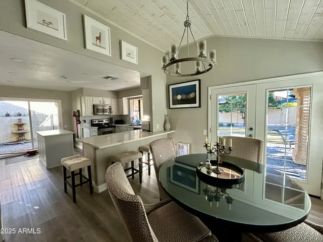 a living room with furniture a dining table and a chandelier