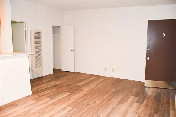 a view of an empty room with wooden floor