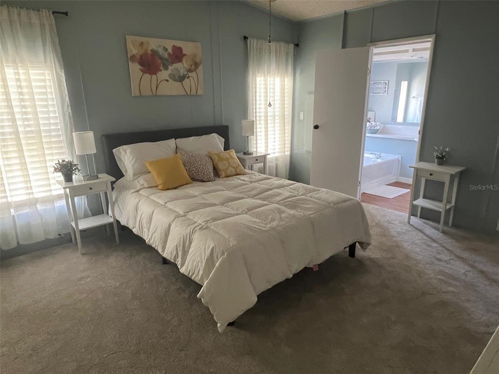 1001 Starkey Road, Unit 177 Largo, FL 33771 - Photo 29 of 44 a bedroom with a bed and a chandelier