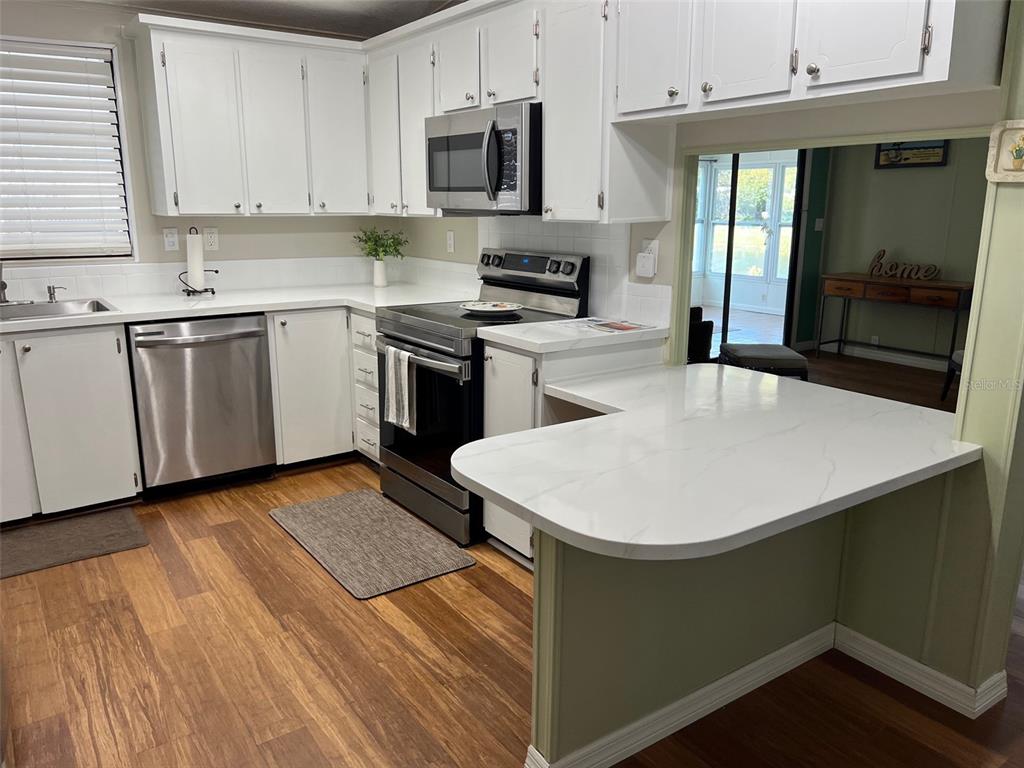 1001 Starkey Road, Unit 177 Largo, FL 33771 - Photo 4 of 44 a kitchen with a sink a stove and cabinets