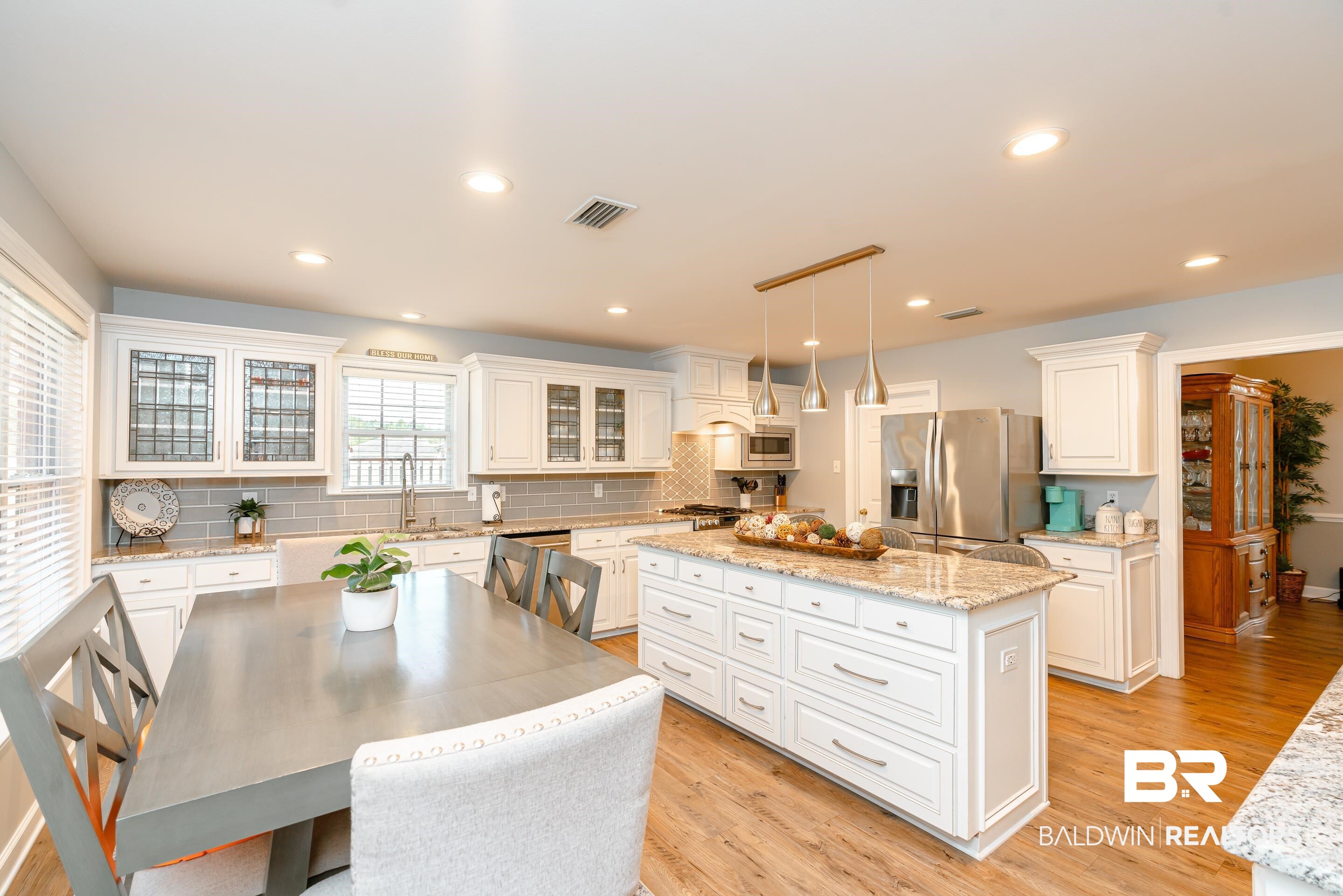 9477 Deerfield Drive Irvington, AL 36544 - Photo 8 of 58 Kitchen featuring white cabinetry, a center island, appliances with stainless steel finishes, and light hardwood / wood-style floors