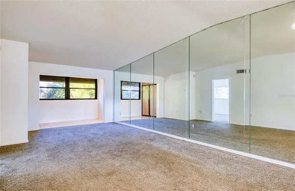 an empty room with windows and closet