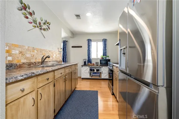 a large kitchen with stainless steel appliances granite countertop a refrigerator and a sink