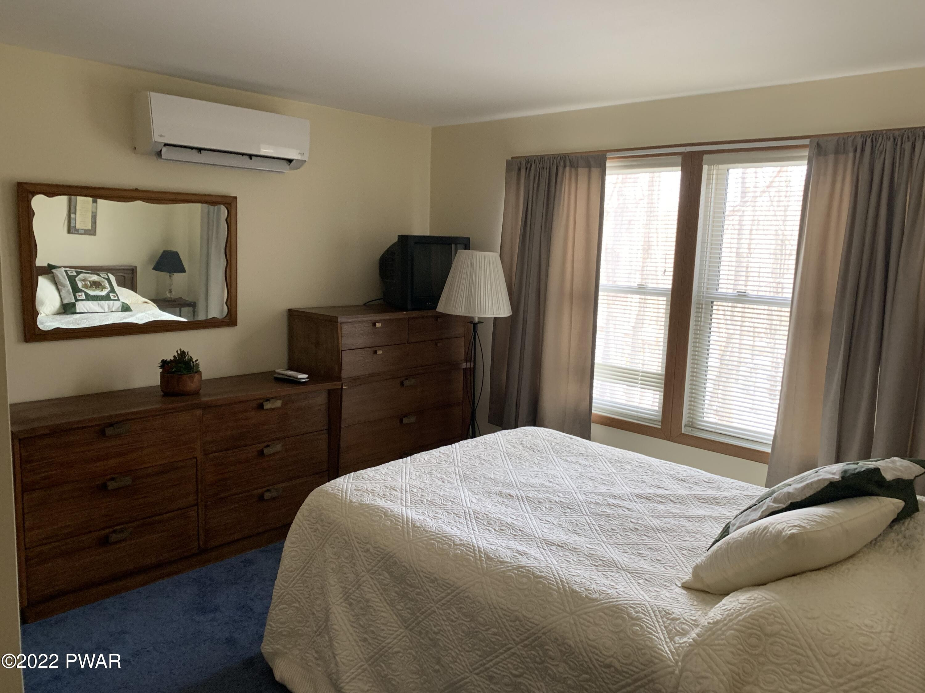111 Rodeo Lane Hawley, PA 18428 - Photo 11 of 23 a bedroom with a bed and a flat tv screen on dresser
