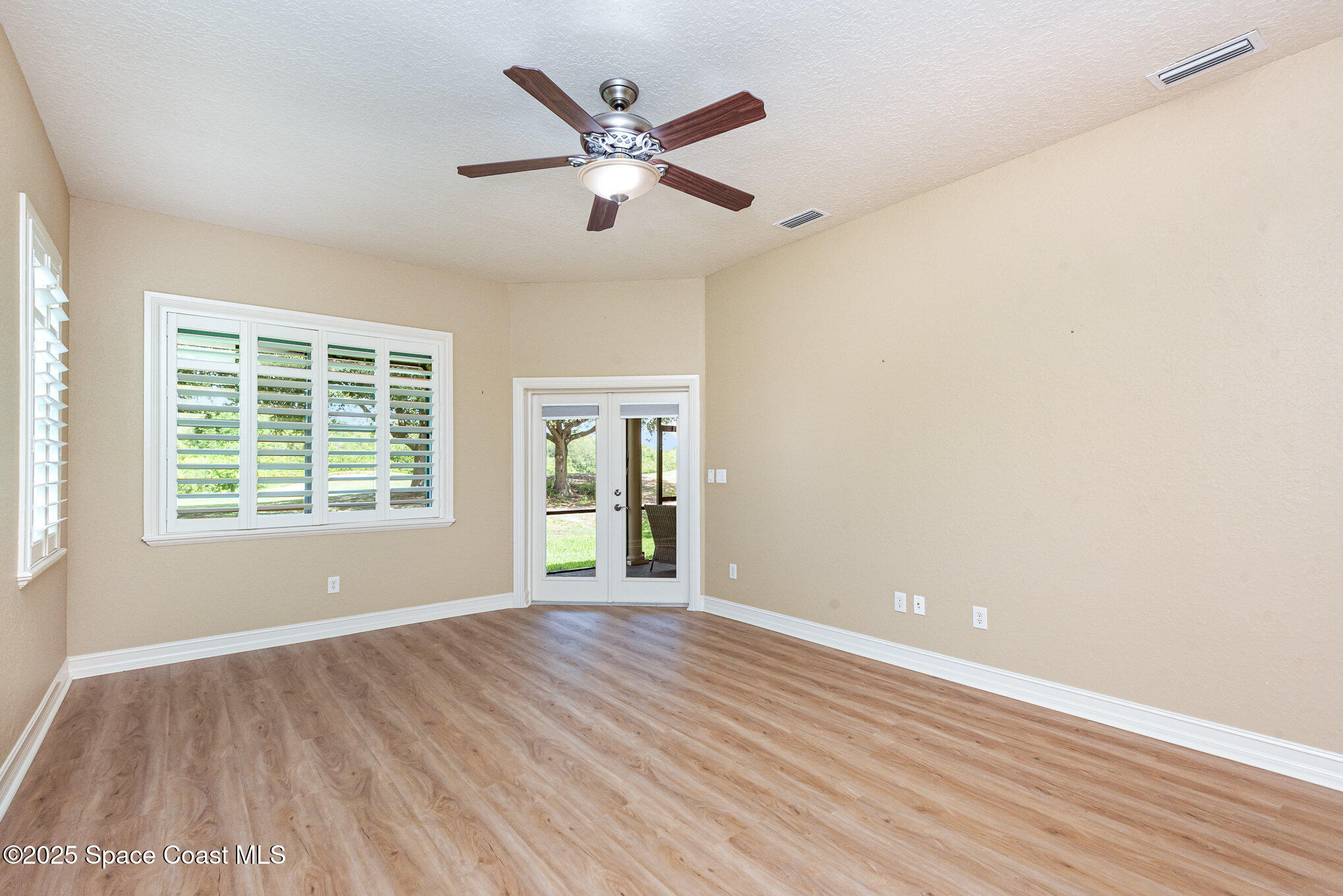 3260 Quantum Place Mims, FL 32754 - Photo 17 of 43 an empty room with wooden floor and windows