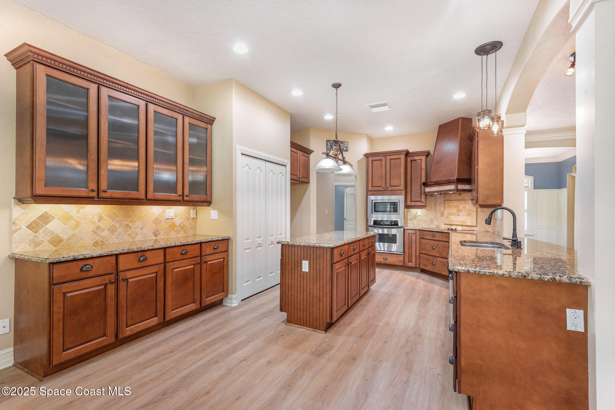 3260 Quantum Place Mims, FL 32754 - Photo 2 of 43 a large kitchen with stainless steel appliances kitchen island granite countertop a large counter top and wooden cabinets